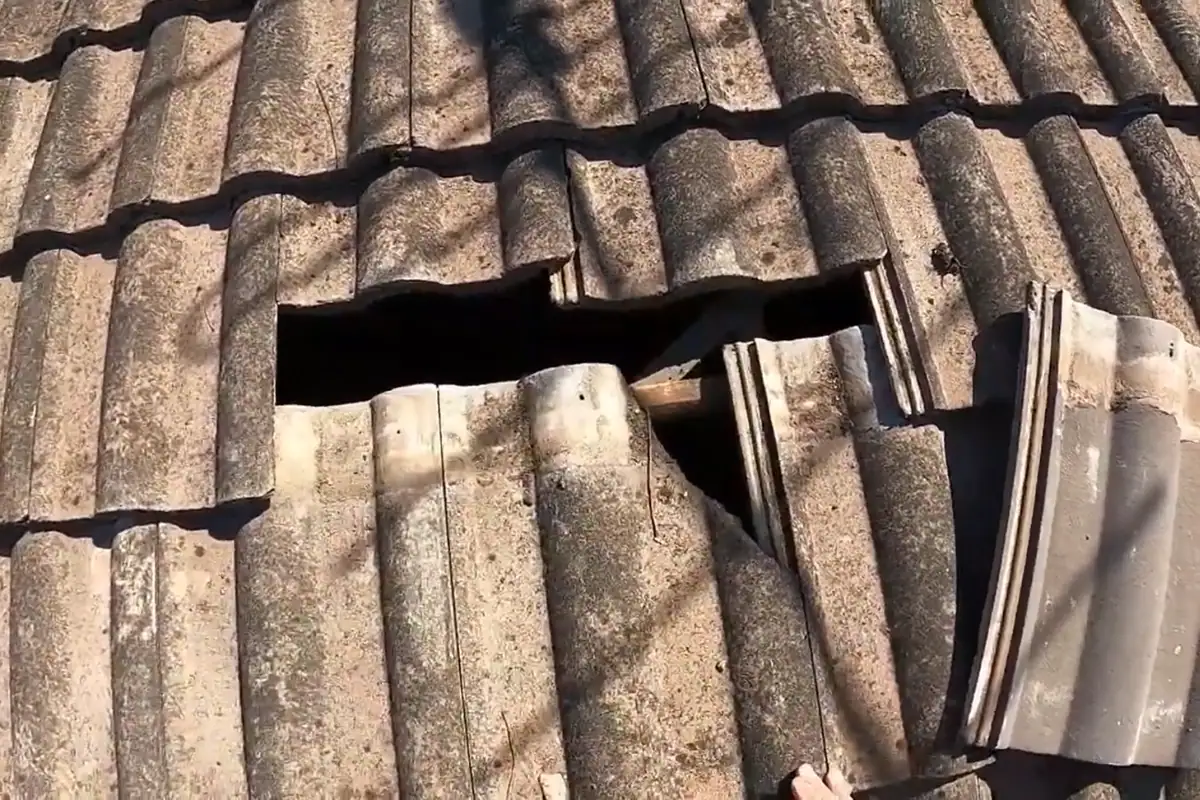 Tile roof section with a broken tile before repair